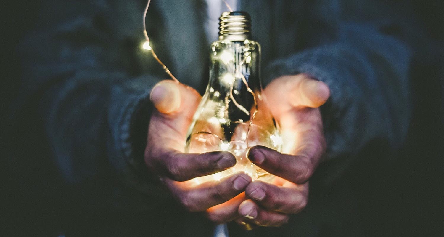 Ampoule dans les mains d'un business man illustrant le développement économique